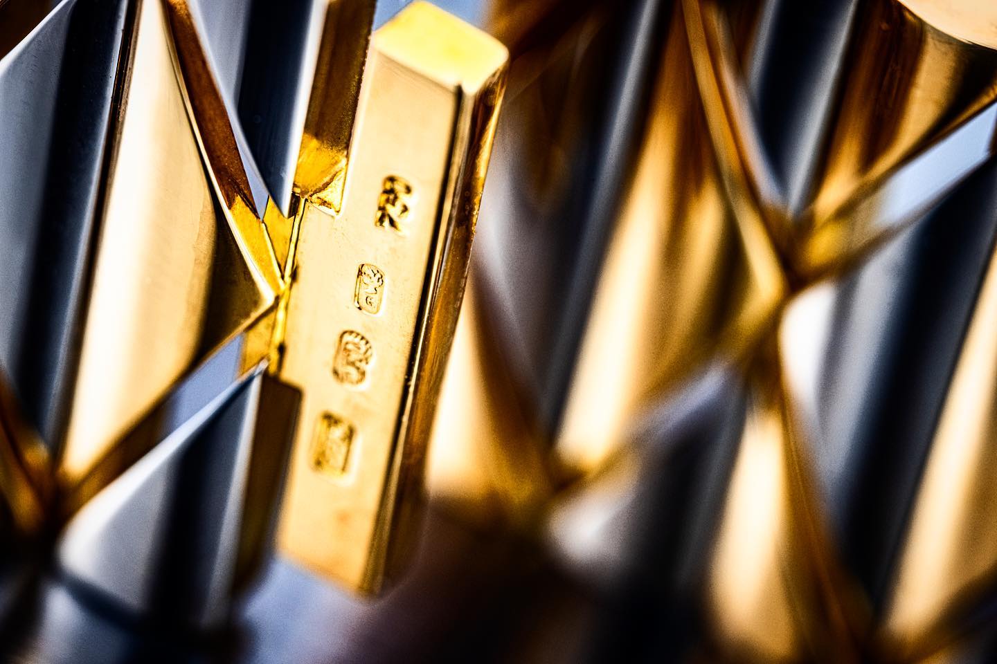 Extreme close-up of gold watch bracelet and hallmark detail